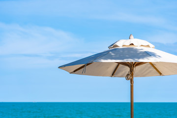 Obraz na płótnie Canvas Beautiful umbrella and chair around beach sea ocean with blue sky for travel