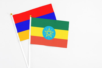 Ethiopia and Armenia stick flags on white background. High quality fabric, miniature national flag. Peaceful global concept.White floor for copy space.