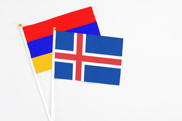Obraz premium Iceland and Armenia stick flags on white background. High quality fabric, miniature national flag. Peaceful global concept.White floor for copy space.
