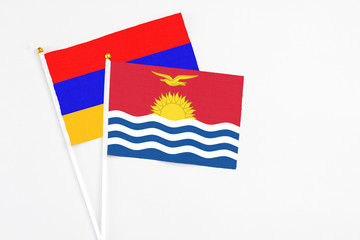Kiribati and Armenia stick flags on white background. High quality fabric, miniature national flag. Peaceful global concept.White floor for copy space.