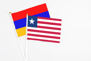 Liberia and Armenia stick flags on white background. High quality fabric, miniature national flag. Peaceful global concept.White floor for copy space.
