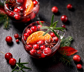 Christmas mulled wine with addition of cranberries, citrus fruits, aromatic spices and herbs in...