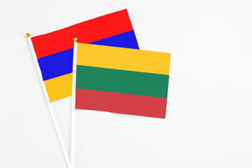 Lithuania and Armenia stick flags on white background. High quality fabric, miniature national flag. Peaceful global concept.White floor for copy space.