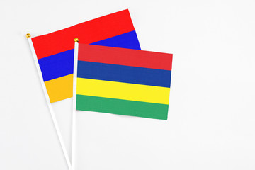 Mauritius and Armenia stick flags on white background. High quality fabric, miniature national flag. Peaceful global concept.White floor for copy space.