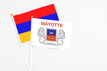 Mayotte and Armenia stick flags on white background. High quality fabric, miniature national flag. Peaceful global concept.White floor for copy space.
