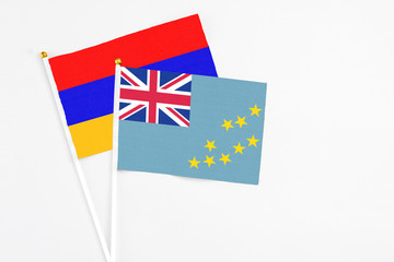 Fototapeta premium Tuvalu and Armenia stick flags on white background. High quality fabric, miniature national flag. Peaceful global concept.White floor for copy space.