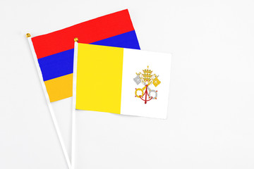 Vatican City and Armenia stick flags on white background. High quality fabric, miniature national flag. Peaceful global concept.White floor for copy space.