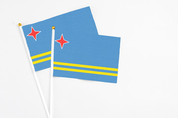 Aruba and Aruba stick flags on white background. High quality fabric, miniature national flag. Peaceful global concept.White floor for copy space.