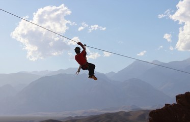 Zipline: man hanging on a rope-way, an exciting adventure - Powered by Adobe