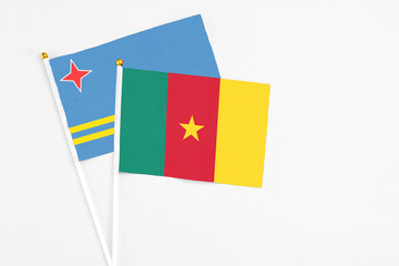 Cameroon and Aruba stick flags on white background. High quality fabric, miniature national flag. Peaceful global concept.White floor for copy space.