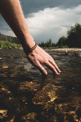 Hand over mountain stream