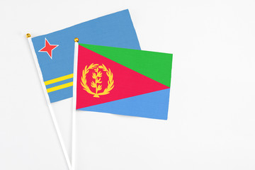 Eritrea and Aruba stick flags on white background. High quality fabric, miniature national flag. Peaceful global concept.White floor for copy space.