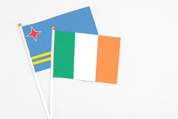 Ireland and Aruba stick flags on white background. High quality fabric, miniature national flag. Peaceful global concept.White floor for copy space.