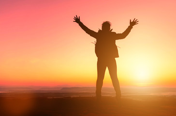 Fototapeta premium Silhouette of happy girl jumping at sunset background. freedom and enjoying concept.