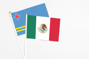 Mexico and Aruba stick flags on white background. High quality fabric, miniature national flag. Peaceful global concept.White floor for copy space.