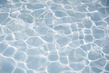 Fototapeta na wymiar Natural blue water surface with bright sun light reflections. water in swimming pool background