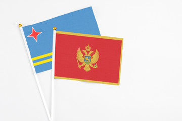 Montenegro and Aruba stick flags on white background. High quality fabric, miniature national flag. Peaceful global concept.White floor for copy space.