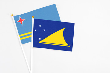Tokelau and Aruba stick flags on white background. High quality fabric, miniature national flag. Peaceful global concept.White floor for copy space.
