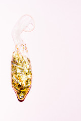 Condom full of golden paillettes  over an pink  background, new year theme party with a  bit of spice, couple love emotional conceptual image,