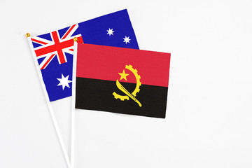 Angola and Australia stick flags on white background. High quality fabric, miniature national flag. Peaceful global concept.White floor for copy space.