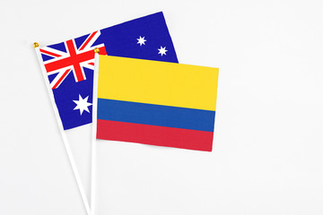 Colombia and Australia stick flags on white background. High quality fabric, miniature national flag. Peaceful global concept.White floor for copy space.