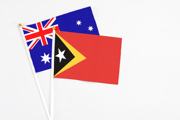Fototapeta premium East Timor and Australia stick flags on white background. High quality fabric, miniature national flag. Peaceful global concept.White floor for copy space.