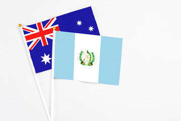 Guatemala and Australia stick flags on white background. High quality fabric, miniature national flag. Peaceful global concept.White floor for copy space.