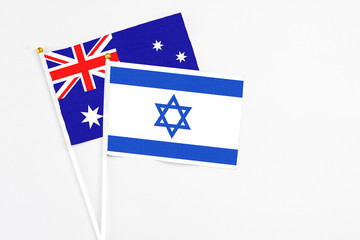 Fototapeta premium Israel and Australia stick flags on white background. High quality fabric, miniature national flag. Peaceful global concept.White floor for copy space.