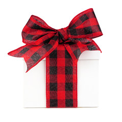White Christmas gift box with red and black buffalo plaid bow and ribbon. Side view isolated on a...