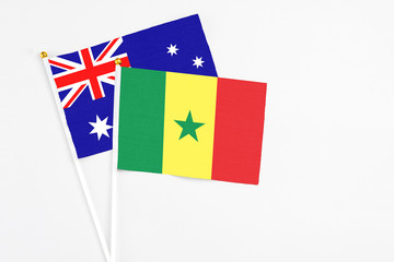 Fototapeta premium Senegal and Australia stick flags on white background. High quality fabric, miniature national flag. Peaceful global concept.White floor for copy space.