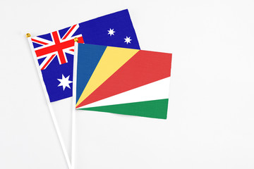 Fototapeta premium Seychelles and Australia stick flags on white background. High quality fabric, miniature national flag. Peaceful global concept.White floor for copy space.