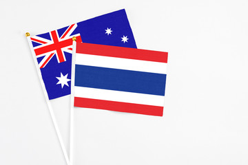 Thailand and Australia stick flags on white background. High quality fabric, miniature national flag. Peaceful global concept.White floor for copy space.