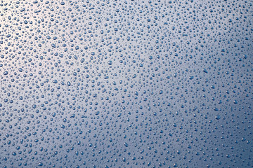 Blue glossy reflective surface and fine random droplets of shower water.