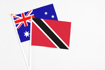 Fototapeta premium Trinidad And Tobago and Australia stick flags on white background. High quality fabric, miniature national flag. Peaceful global concept.White floor for copy space.