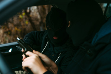 bank robbers putting their mask on prepared to do their next robbery,checking and loading their guns.