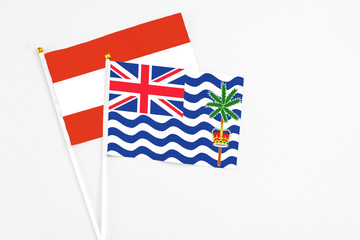 Fototapeta premium British Indian Ocean Territory and Austria stick flags on white background. High quality fabric, miniature national flag. Peaceful global concept.White floor for copy space.