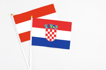 Croatia and Austria stick flags on white background. High quality fabric, miniature national flag. Peaceful global concept.White floor for copy space.