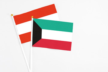 Kuwait and Austria stick flags on white background. High quality fabric, miniature national flag. Peaceful global concept.White floor for copy space.