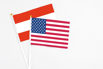 United States and Austria stick flags on white background. High quality fabric, miniature national flag. Peaceful global concept.White floor for copy space.