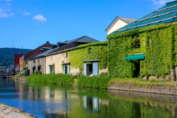 Fototapeta na wymiar Beautiful scenery of Otaru wearhouses along the Otaru canal in summer with blue sky in background.