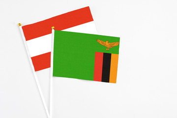 Zambia and Austria stick flags on white background. High quality fabric, miniature national flag. Peaceful global concept.White floor for copy space.