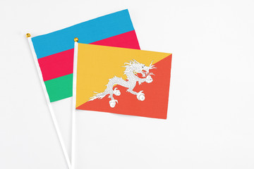 Bhutan and Azerbaijan stick flags on white background. High quality fabric, miniature national flag. Peaceful global concept.White floor for copy space.