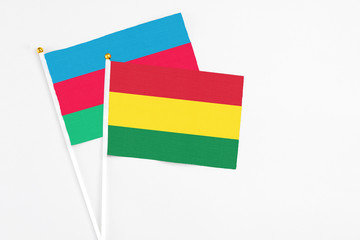 Bolivia and Azerbaijan stick flags on white background. High quality fabric, miniature national flag. Peaceful global concept.White floor for copy space.