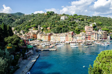 Fototapeta na wymiar Sea bay with beautiful picturesque village called Portofino. Small marina port at the foot of mountain with a beautiful colourful houses village