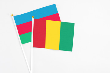 Guinea and Azerbaijan stick flags on white background. High quality fabric, miniature national flag. Peaceful global concept.White floor for copy space.