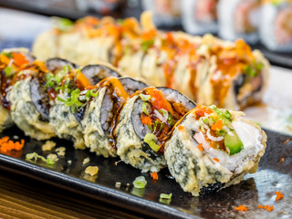 Various sliced sushi on plates on a dining table