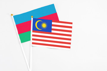 Malaysia and Azerbaijan stick flags on white background. High quality fabric, miniature national flag. Peaceful global concept.White floor for copy space.