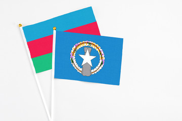 Northern Mariana Islands and Azerbaijan stick flags on white background. High quality fabric, miniature national flag. Peaceful global concept.White floor for copy space.