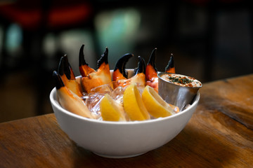 Fresh Stone Crab Claws with lemon and lime, sauce and ice in a dish in a restaurant