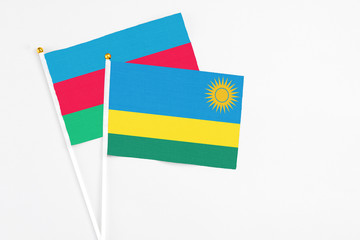 Rwanda and Azerbaijan stick flags on white background. High quality fabric, miniature national flag. Peaceful global concept.White floor for copy space.